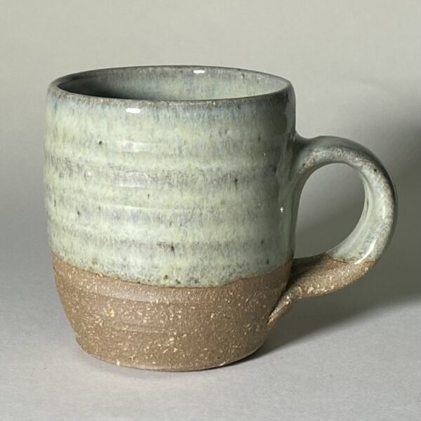 medium pottery mug decorated with a green glaze over an iron-rich clay